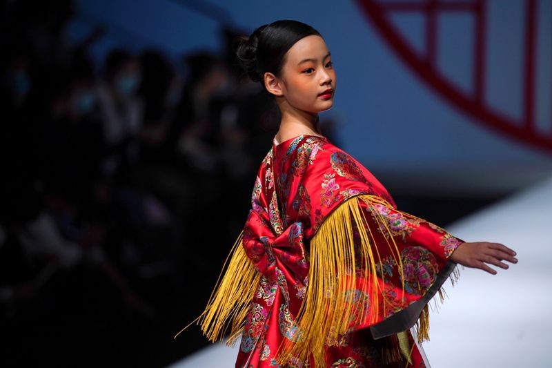 A child model presents a creation by Qingmei Lou at the China fashion week. Image Credit: REUTERS